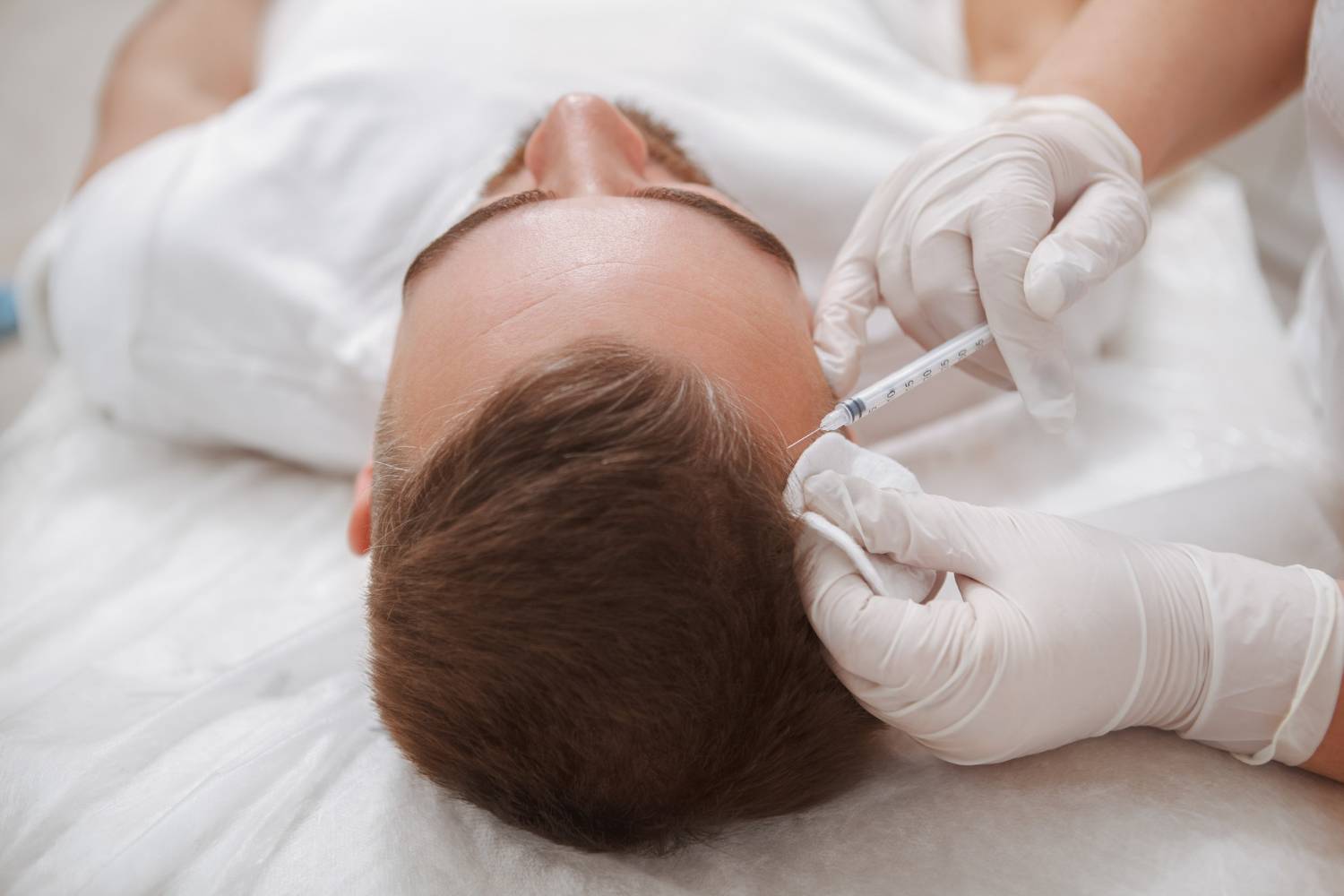 professional-aesthetician-giving-hairloss-treatment-male-client-injecting-vitamins-into-his-scalp