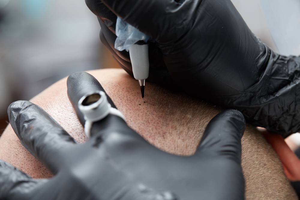 Cosmetologist,Making,Permanent,Makeup,On,Man,Head,-,Tricopigmentation