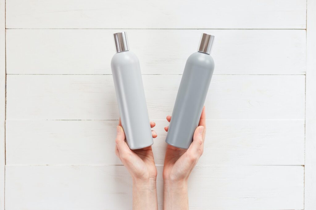 The woman chooses one of the two shampoos in the bottle hair loss