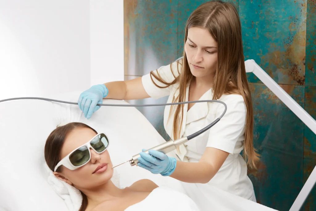 A dermatologist doing laser treatment on a lady patient